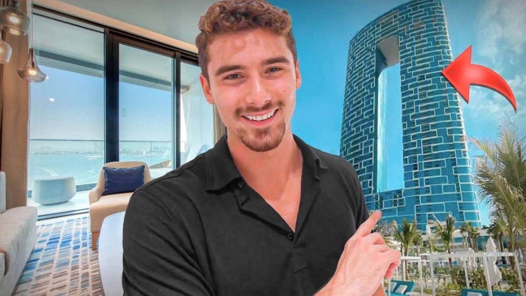 Iman Gadzhi en chemise noire devant sa résidence de luxe en bord de mer à Dubaï